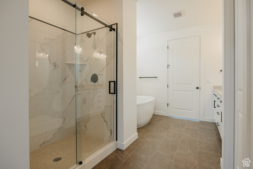 Full bathroom featuring a marble finish shower, a soaking tub, marble finish floors, baseboards, and vanity