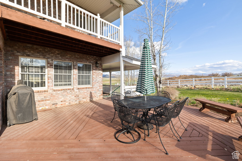 Deck featuring fence, outdoor dining area, and a grill