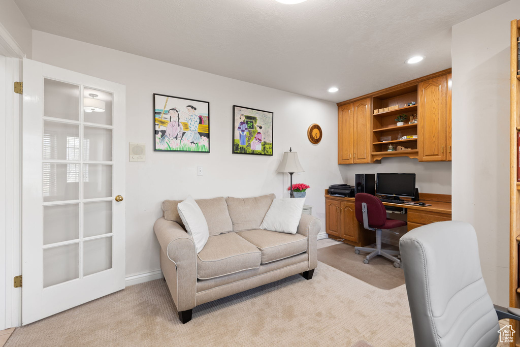 Home office featuring recessed lighting, built in desk, and light carpet
