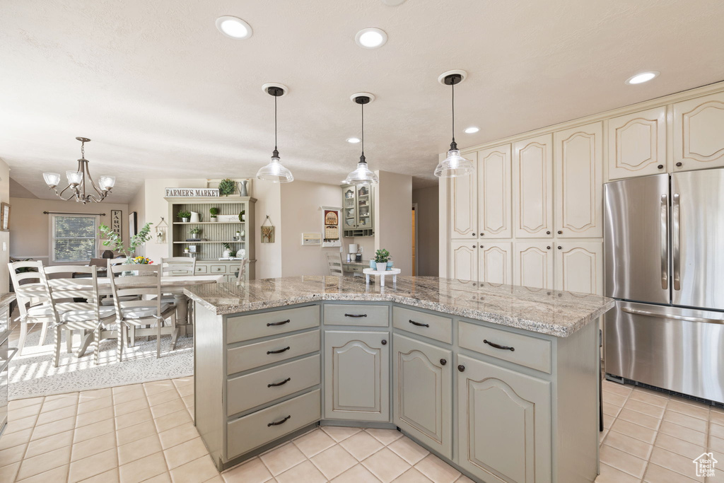 Kitchen with decorative light fixtures, a center island, a chandelier, stainless steel fridge, and recessed lighting