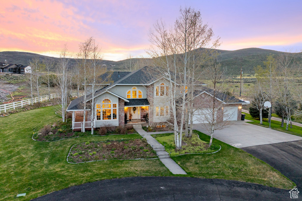 Traditional home featuring fence, a front lawn, a porch, a mountain view, and driveway