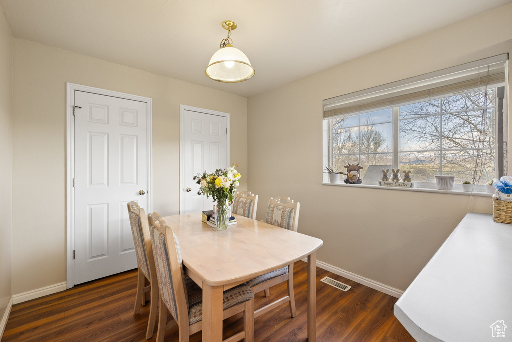 Dining space featuring baseboards, dark wood finished floors, and visible vents