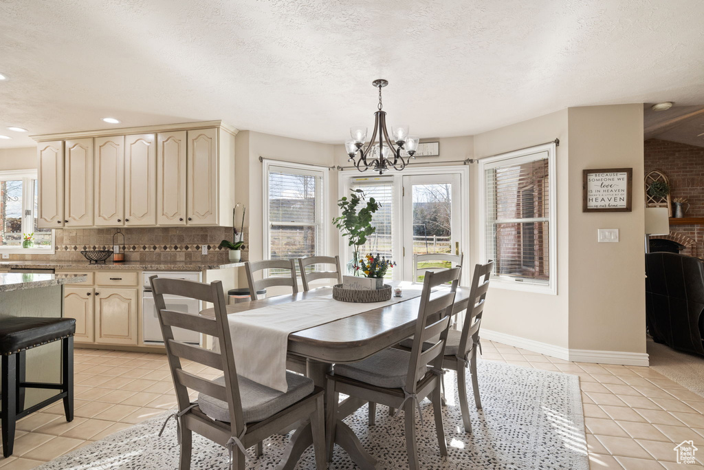Dining room with recessed lighting, a chandelier, light tile patterned floors, and a wealth of natural light