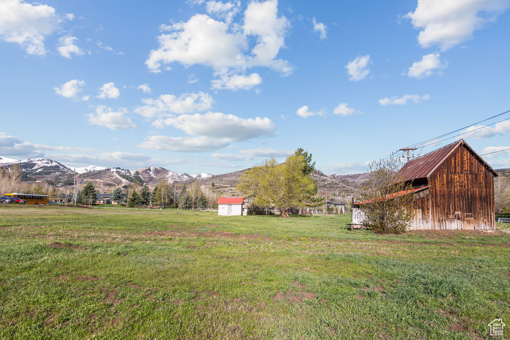View of yard featuring an outdoor structure, a mountain view, and a storage unit