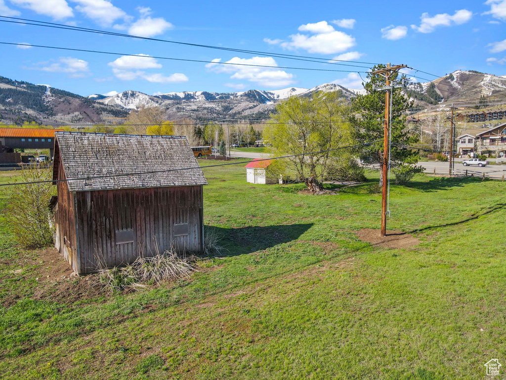 View of yard featuring an outdoor structure, a mountain view, and a shed