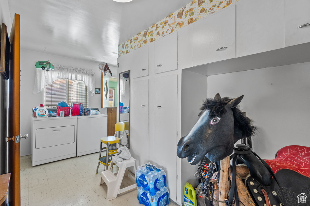 Interior space featuring light floors, cabinet space, and washer and clothes dryer