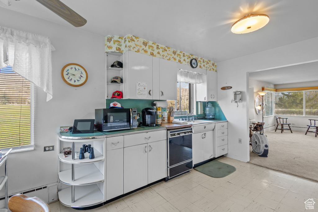 Kitchen featuring open shelves, white cabinets, a baseboard radiator, and black appliances