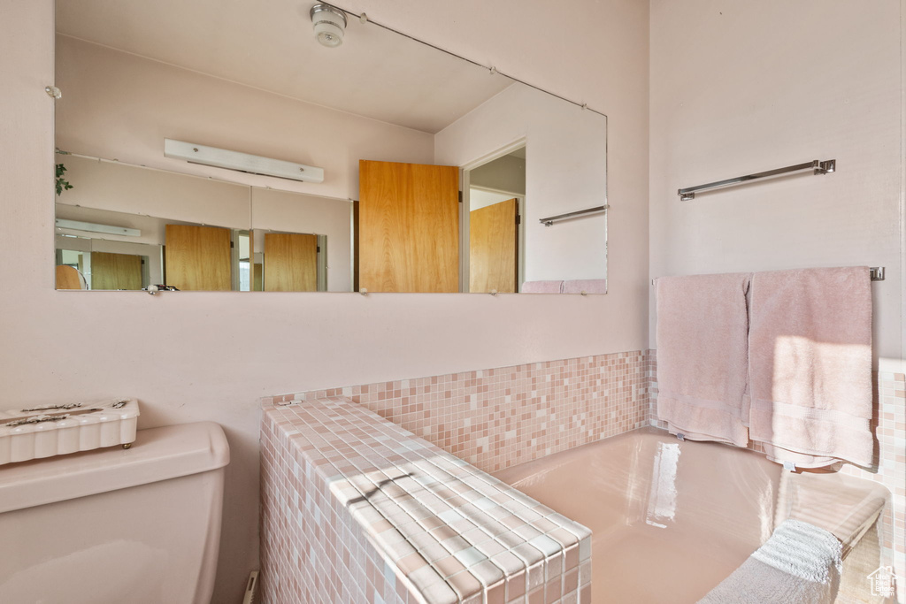 Bathroom with a wall mounted air conditioner and toilet