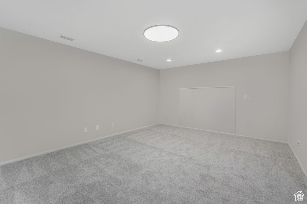 Empty room with recessed lighting, baseboards, light colored carpet, and visible vents