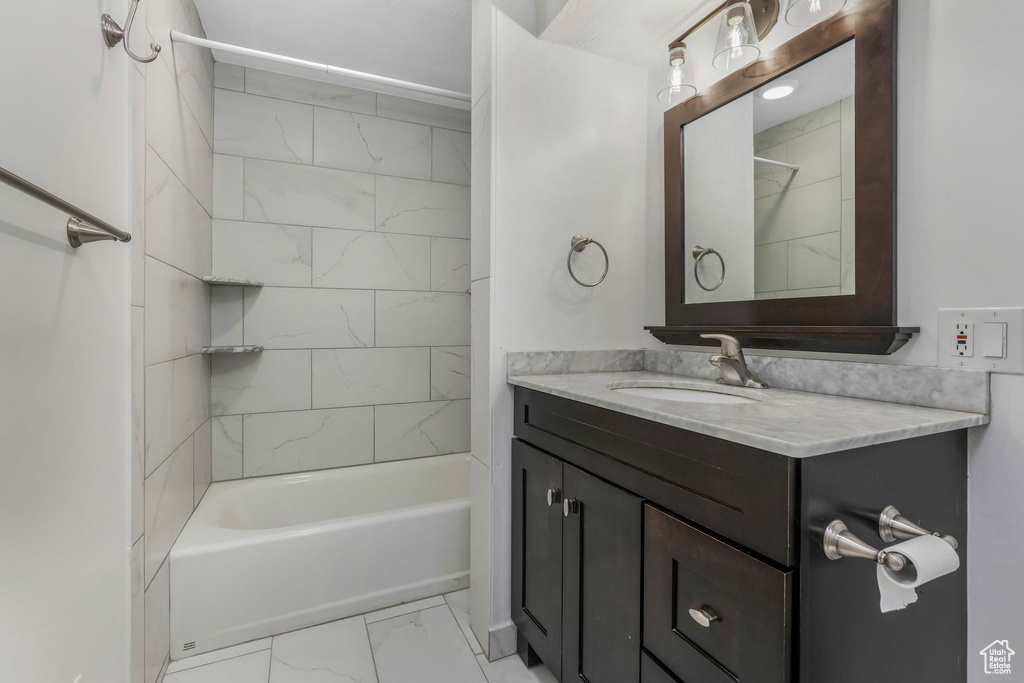 Bathroom with shower / washtub combination, marble finish floor, and vanity