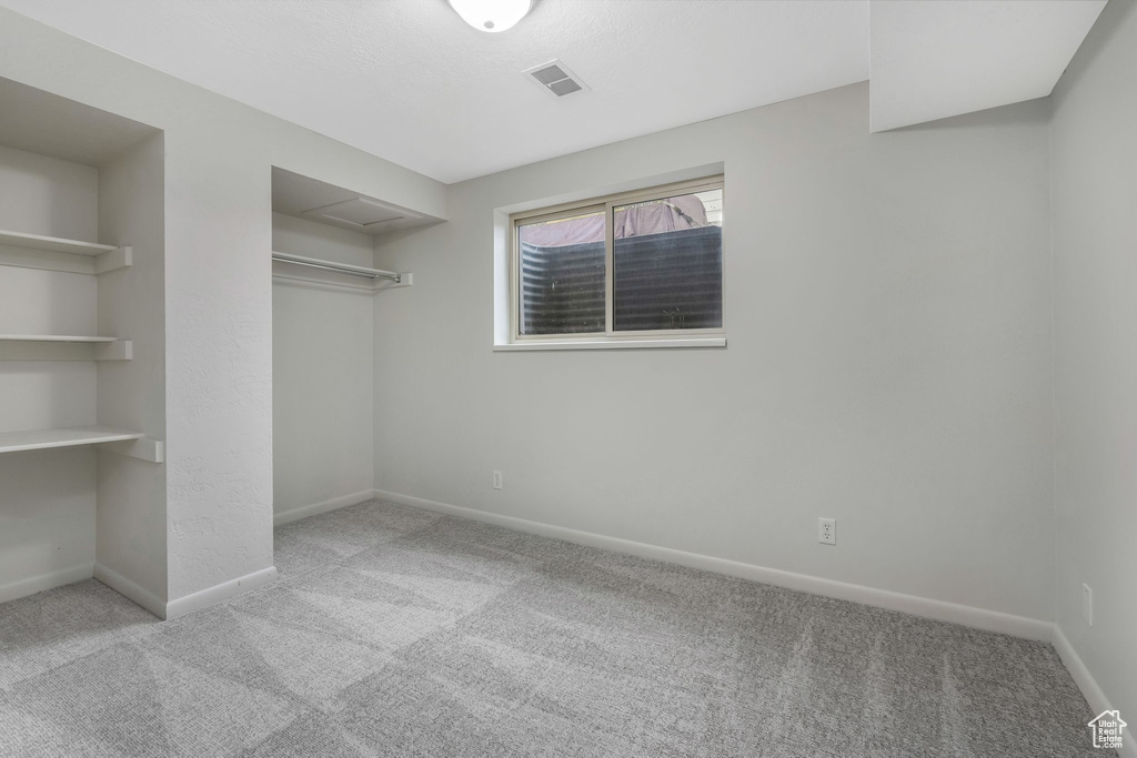 Unfurnished bedroom with baseboards, carpet, a closet, and visible vents