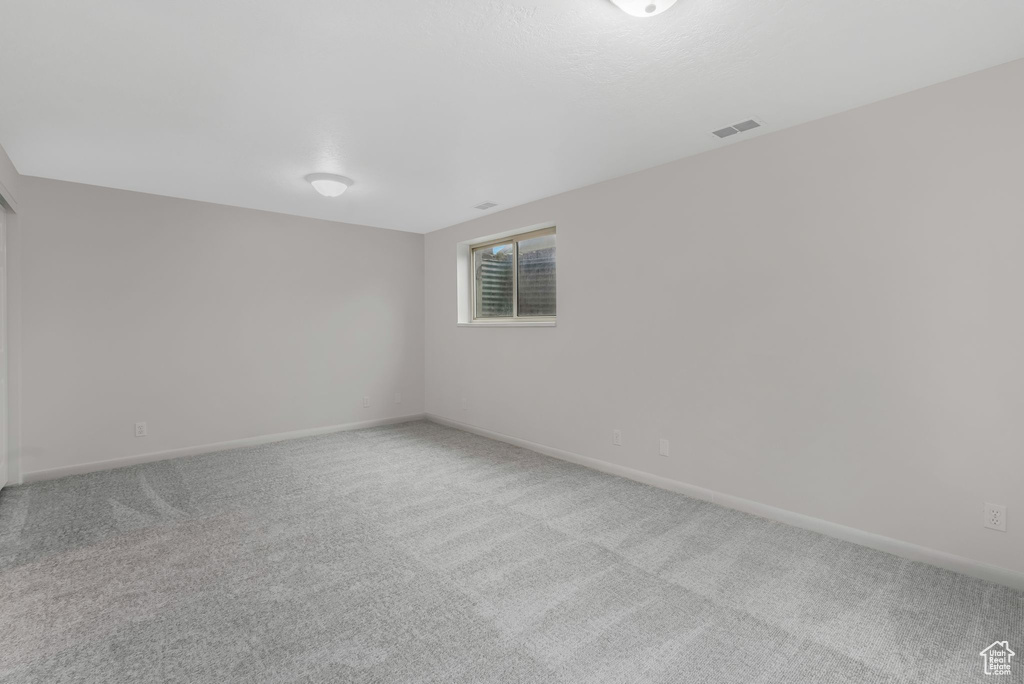 Carpeted spare room with baseboards and visible vents