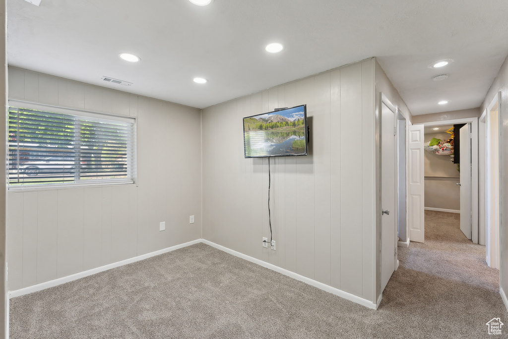 Carpeted spare room featuring baseboards, recessed lighting, and visible vents