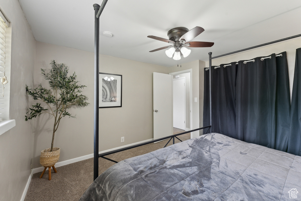 Carpeted bedroom featuring baseboards and ceiling fan