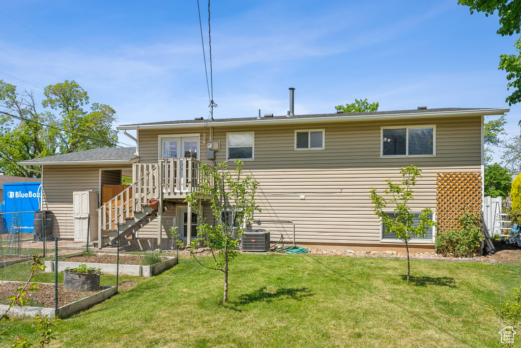 Back of house with a garden, french doors, a lawn, fence, and cooling unit