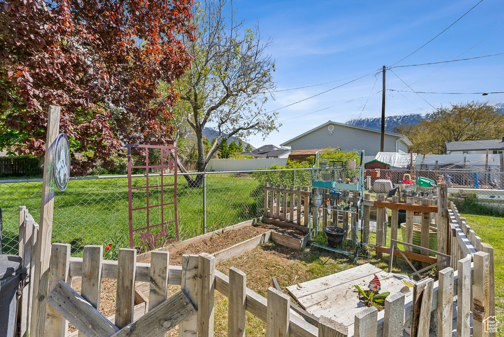 View of yard with fence and a vegetable garden