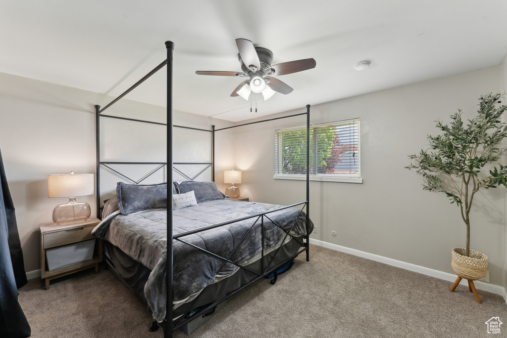 Carpeted bedroom featuring a ceiling fan and baseboards