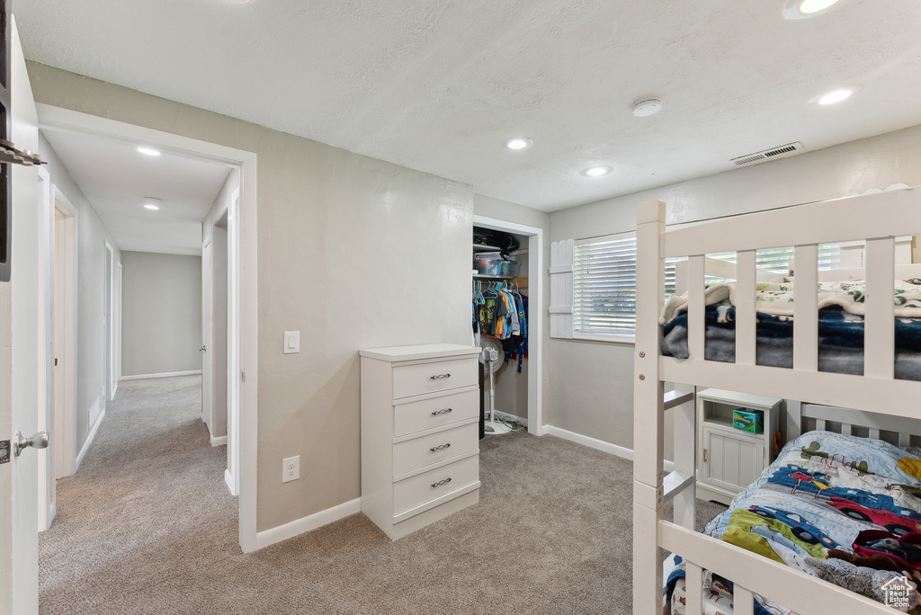 Bedroom featuring baseboards, light carpet, recessed lighting, and visible vents