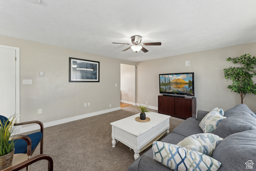 Living area with baseboards, carpet, and a ceiling fan
