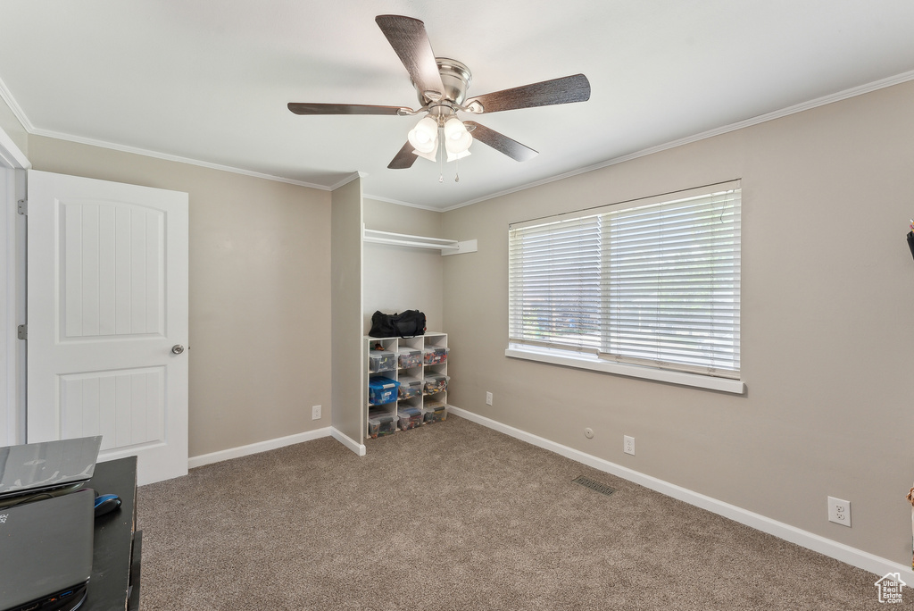 Carpeted bedroom featuring baseboards, ornamental molding, ceiling fan, and visible vents