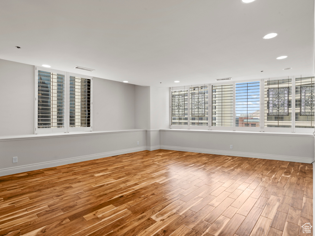 Empty room featuring baseboards, recessed lighting, and wood finished floors