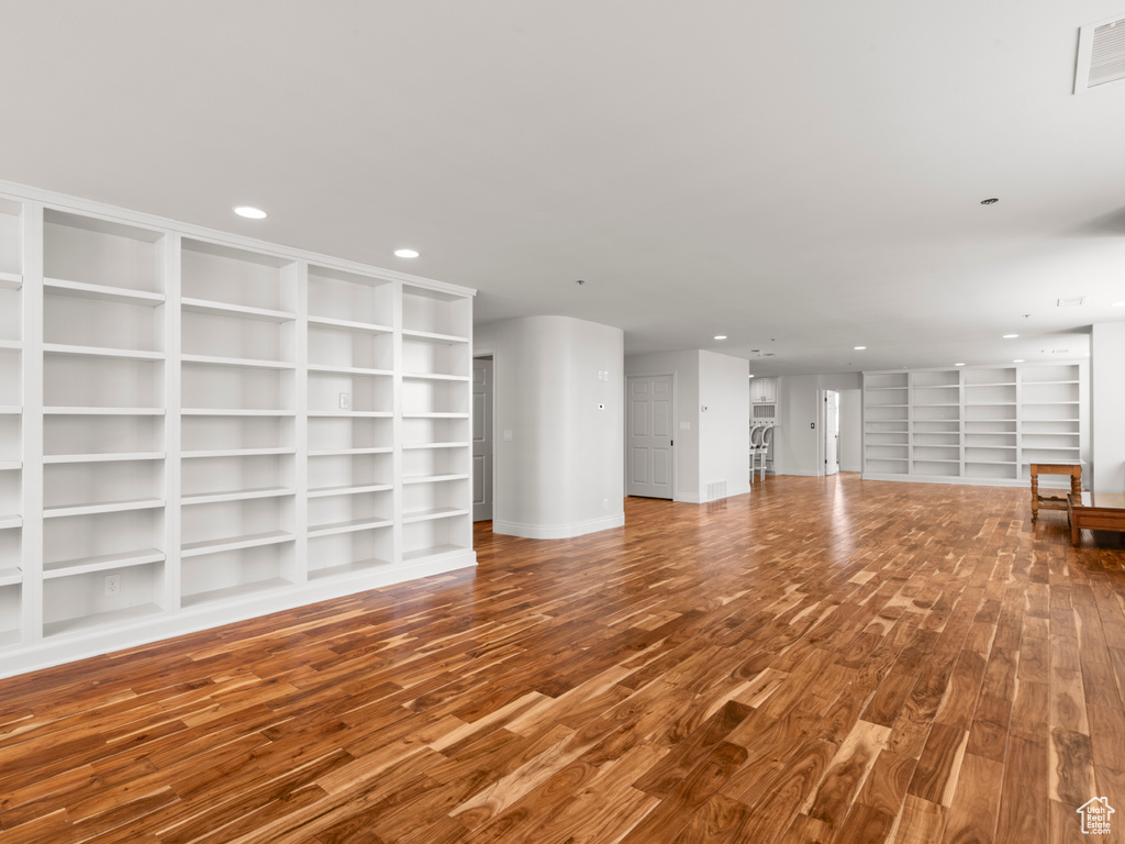 Unfurnished living room featuring visible vents, recessed lighting, built in features, and wood finished floors