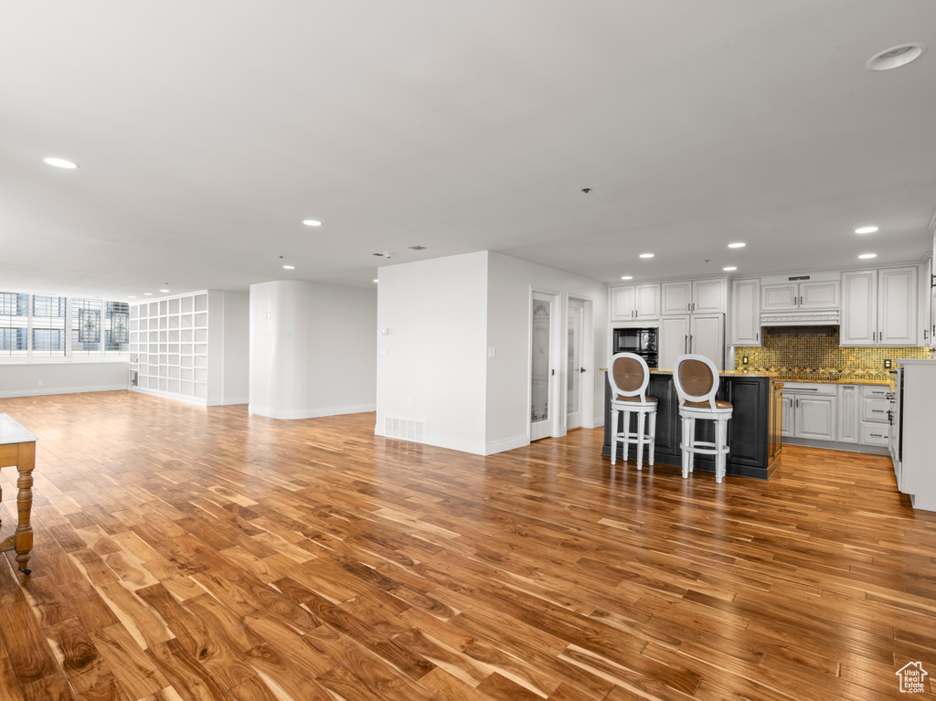 Living room featuring recessed lighting, baseboards, and light wood-style flooring