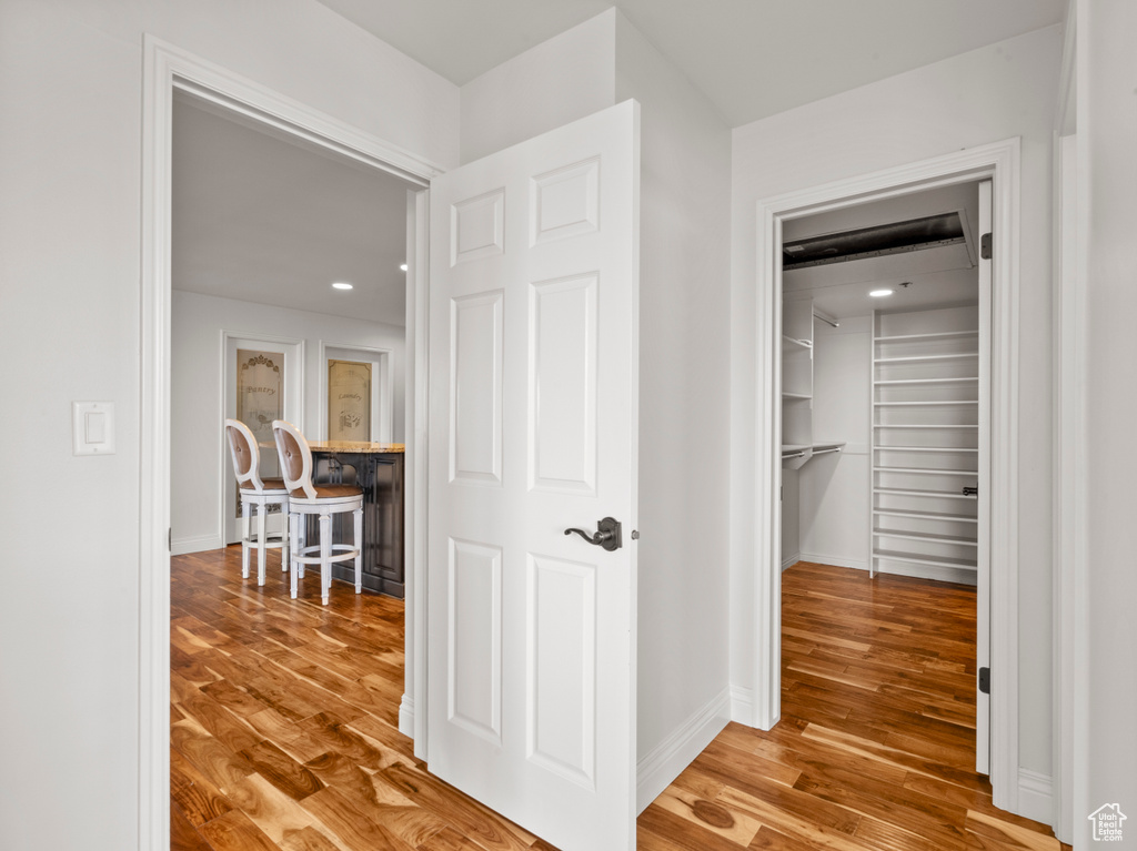 Corridor with baseboards, recessed lighting, and wood finished floors