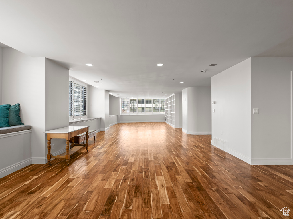 Interior space featuring baseboards, recessed lighting, wood finished floors, and visible vents