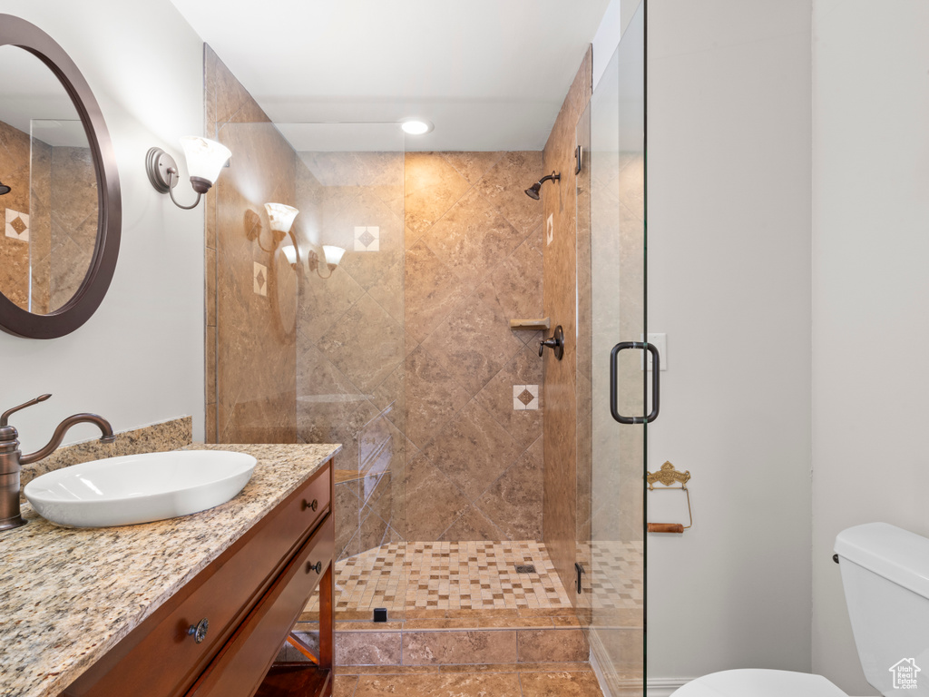 Full bathroom featuring vanity, toilet, recessed lighting, and a stall shower