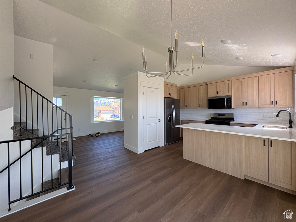 Kitchen with backsplash, appliances with stainless steel finishes, a sink, lofted ceiling, and light brown cabinets