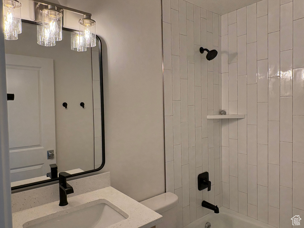 Bathroom with toilet, bathing tub / shower combination, and vanity