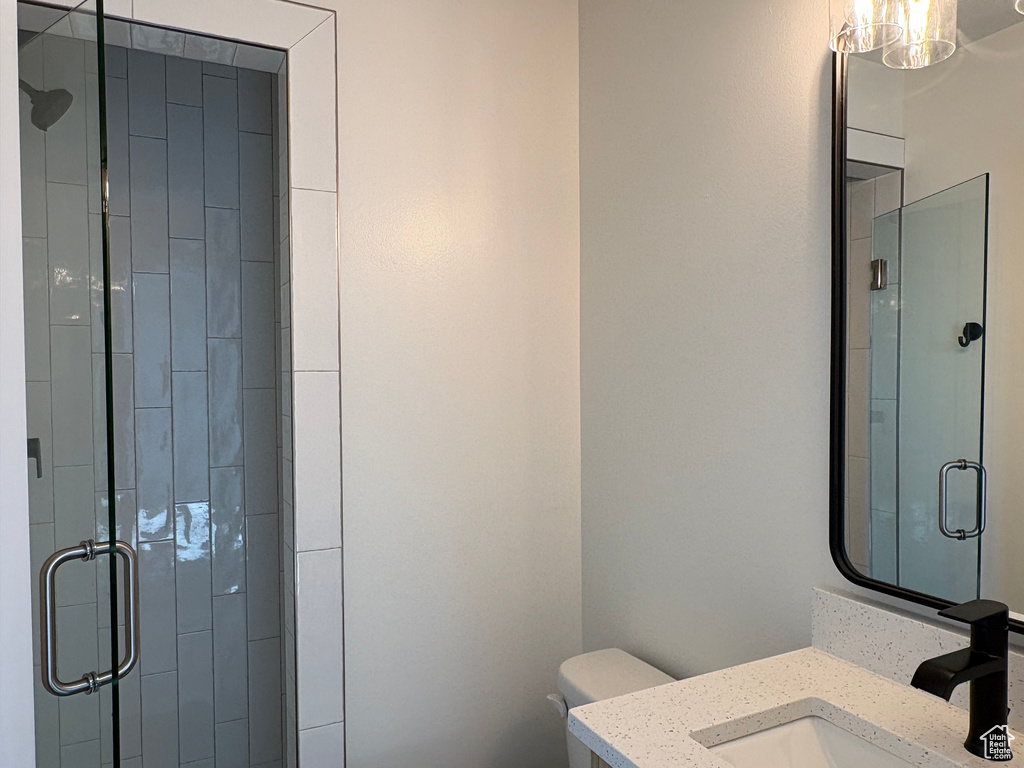 Full bath with vanity, a stall shower, and toilet