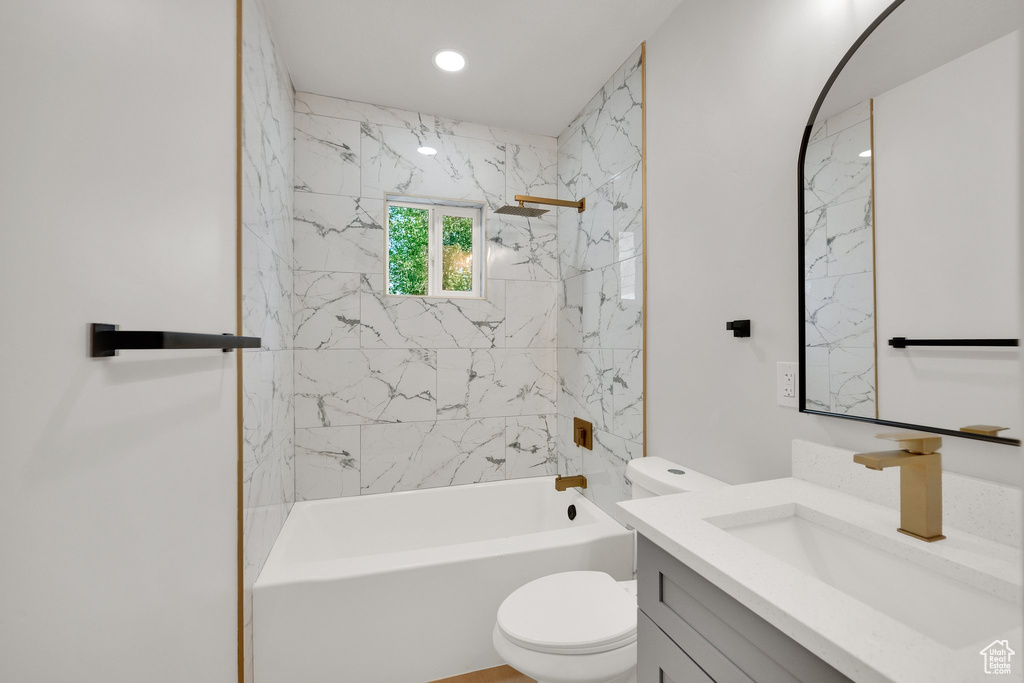 Bathroom featuring vanity, toilet, and shower / washtub combination