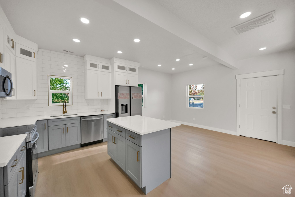 Kitchen featuring visible vents, light wood-style floors, appliances with stainless steel finishes, and gray cabinetry