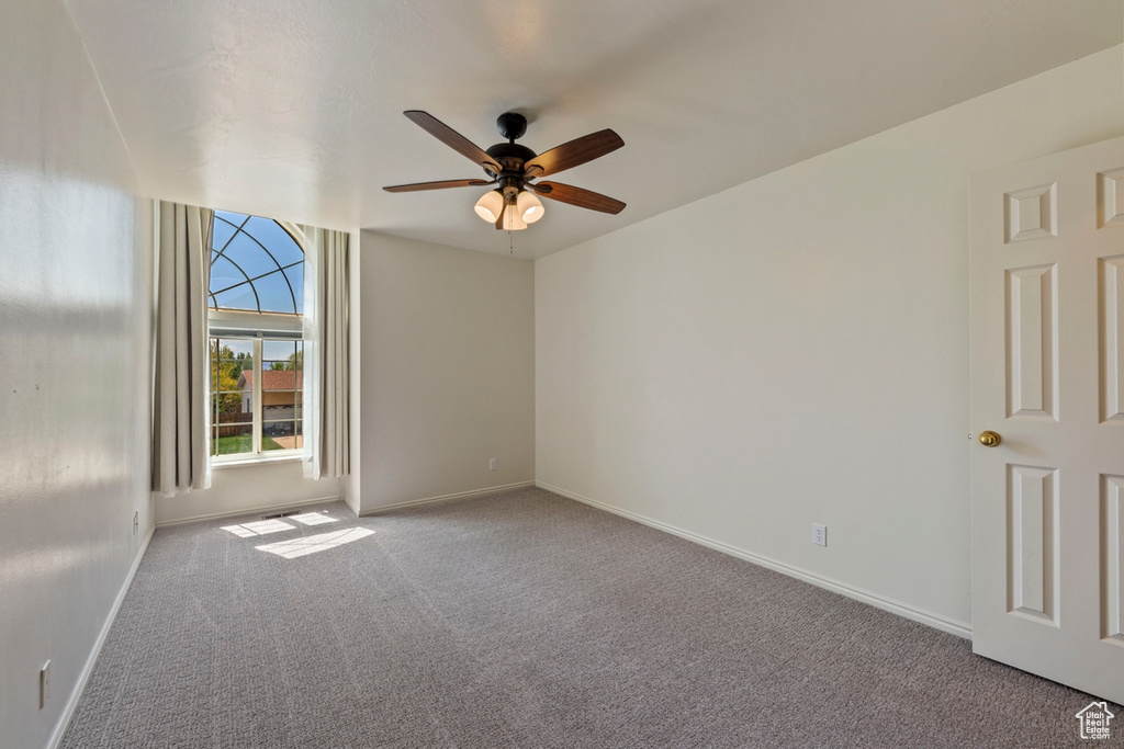 Unfurnished room featuring baseboards, a ceiling fan, and carpet