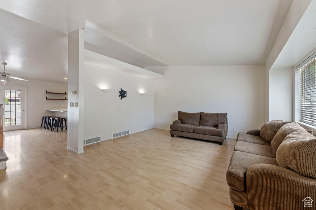 Living room with visible vents, ceiling fan, and wood finished floors