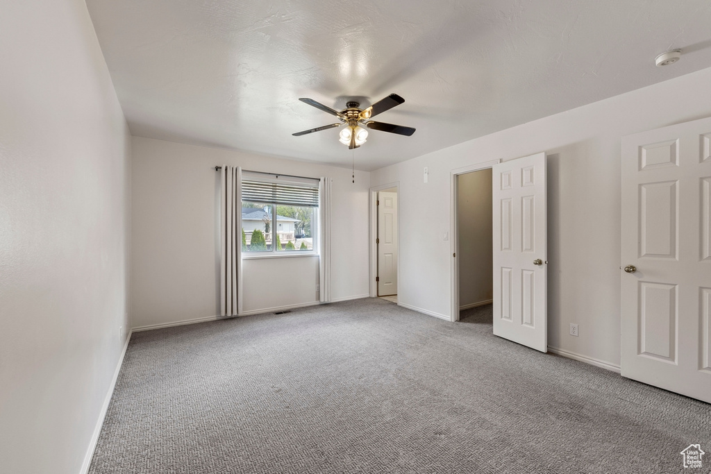 Unfurnished bedroom featuring carpet floors, a ceiling fan, and baseboards