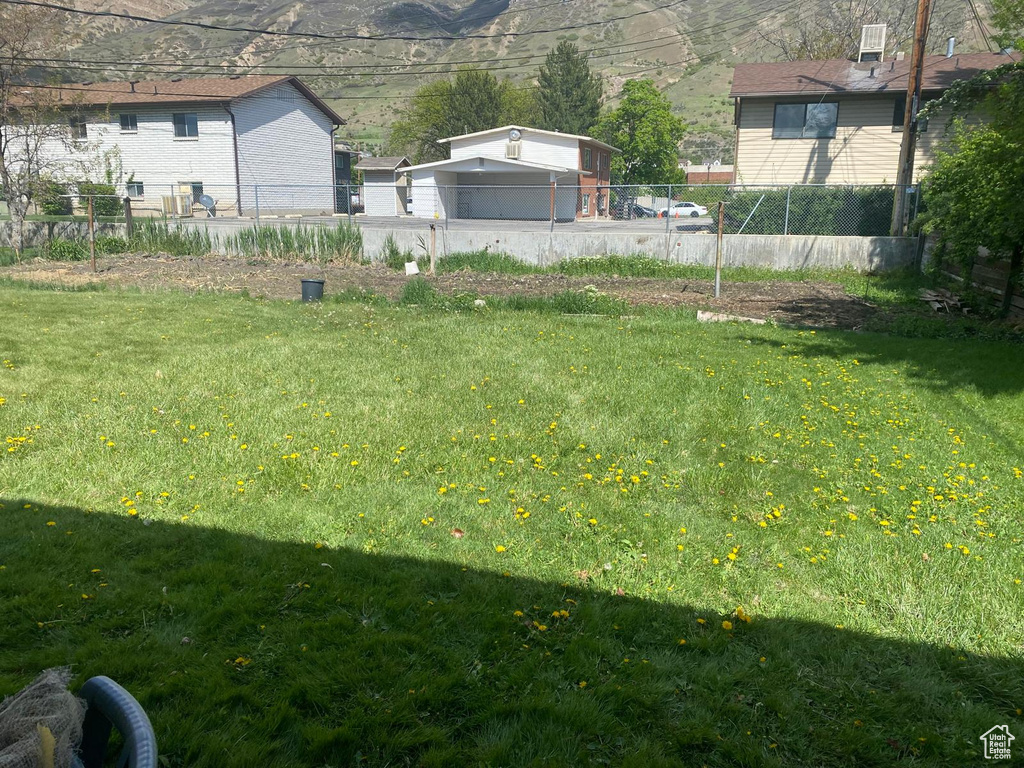 View of yard featuring fence and a mountain view