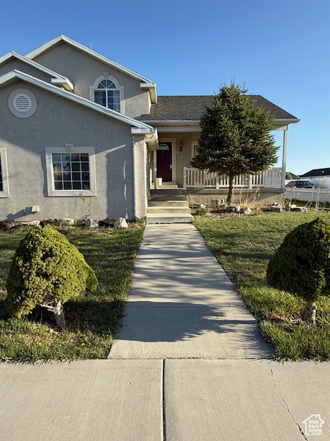 View of front of home with stucco siding and a porch