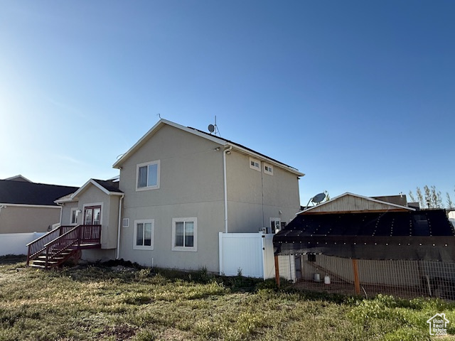 Back of house with fence and stucco siding