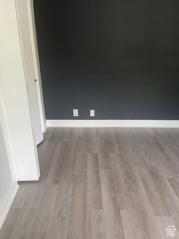 Unfurnished room with baseboards and wood finished floors