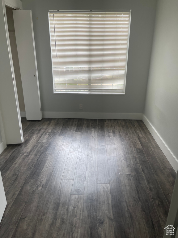 Empty room with baseboards and dark wood finished floors