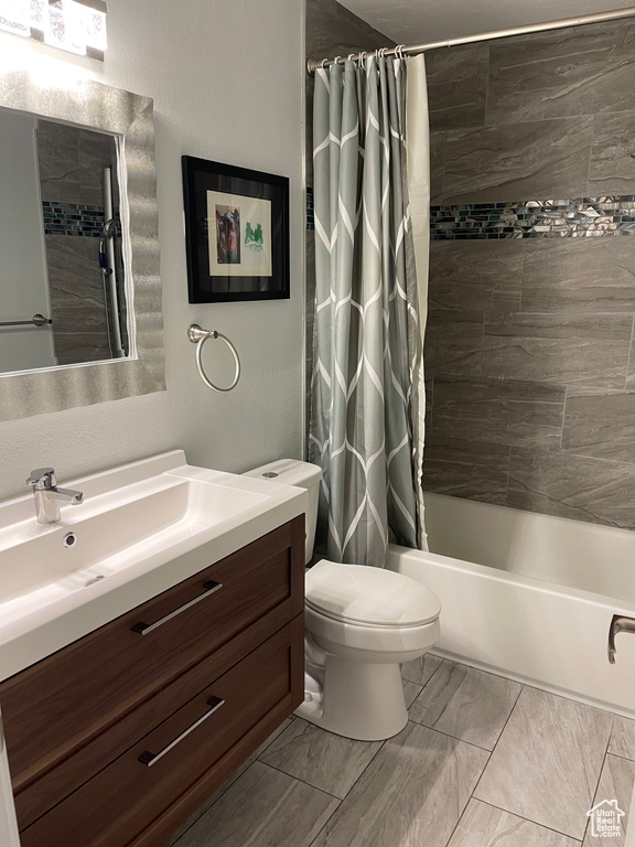 Full bath with vanity, toilet, shower / bathtub combination with curtain, and marble finish floor