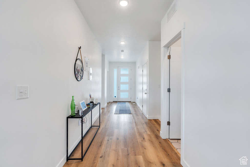 Corridor featuring recessed lighting, baseboards, visible vents, and light wood-style floors
