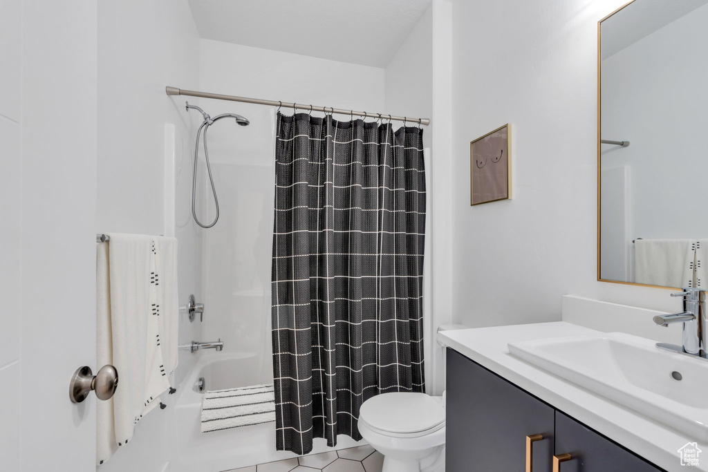 Bathroom with toilet, shower / bathtub combination with curtain, and vanity