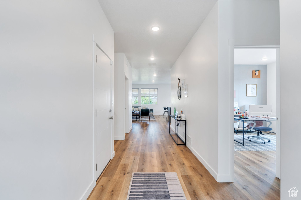 Corridor with recessed lighting, baseboards, and light wood-style floors