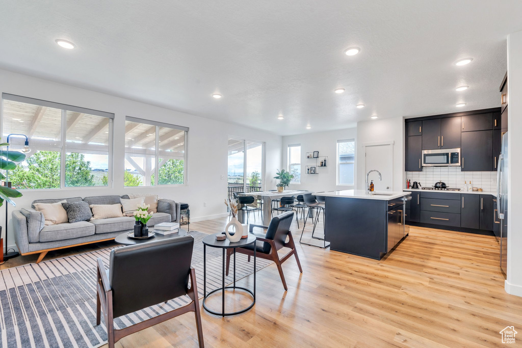 Living area featuring recessed lighting, baseboards, and light wood finished floors