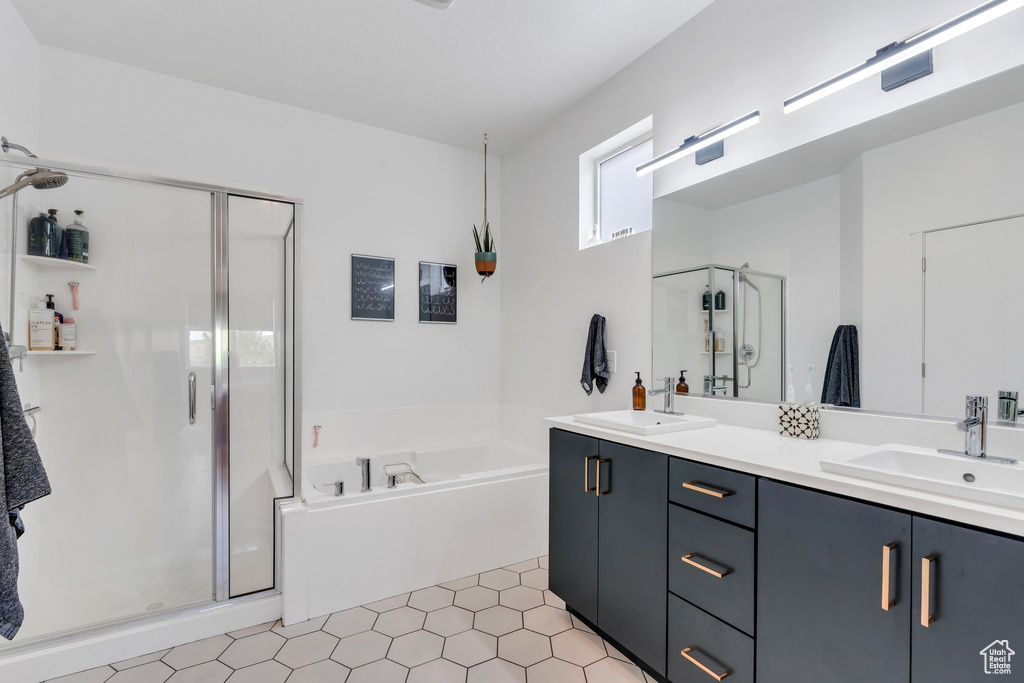 Bathroom with double vanity, a shower stall, a sink, and a bath