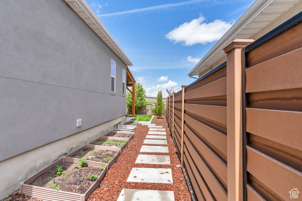 View of yard with fence and a garden